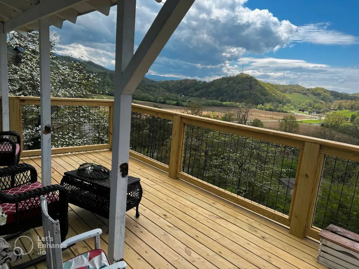 A peaceful wooden deck with outdoor seating, providing a direct view of the mountains. The scene is calm and bathed in natural light, with the potential for observing sunrises, stargazing, and seasonal blooms.