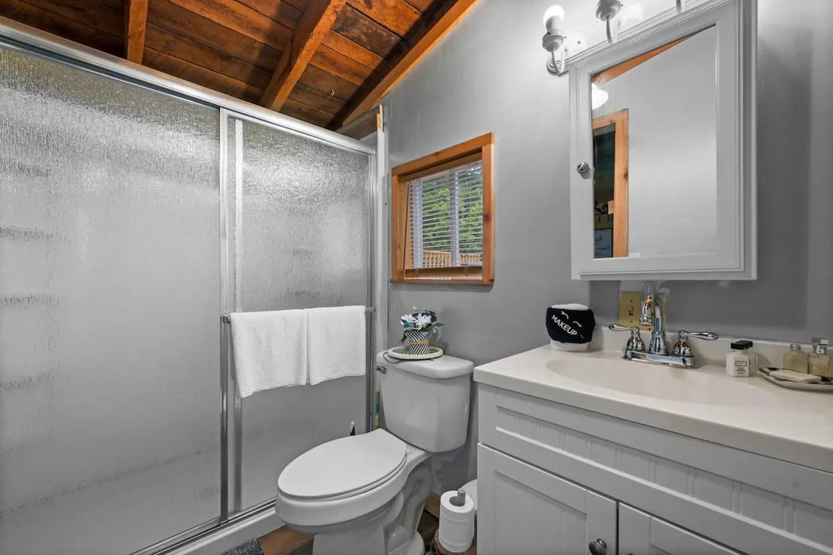 A pristine bathroom with a walk-in shower, vanity, and a window that allows daylight to brighten the space. The atmosphere is refreshing and serene, inviting guests to unwind after a day of adventure.